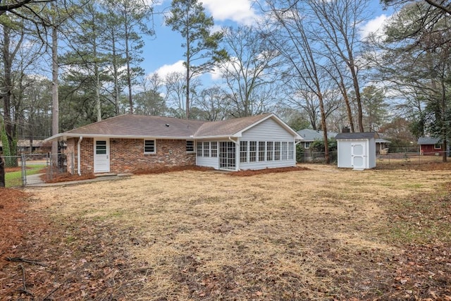 rear view of house featuring a storage shed, a yard, and a sunroom