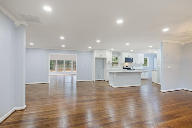 unfurnished living room featuring visible vents, recessed lighting, crown molding, baseboards, and dark wood-style flooring