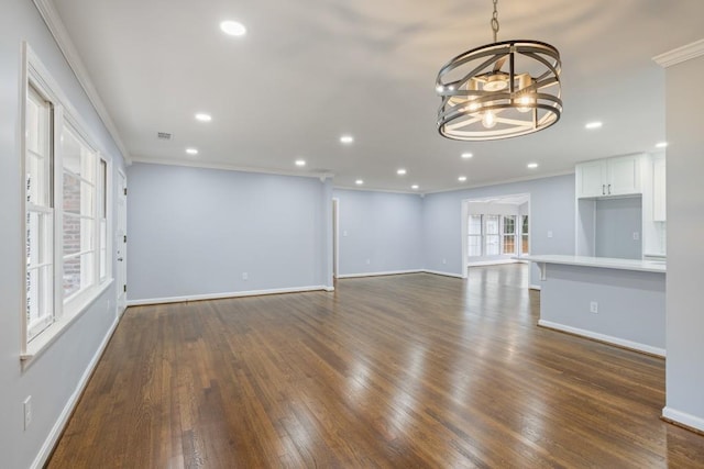 unfurnished living room featuring an inviting chandelier, crown molding, and dark hardwood / wood-style flooring