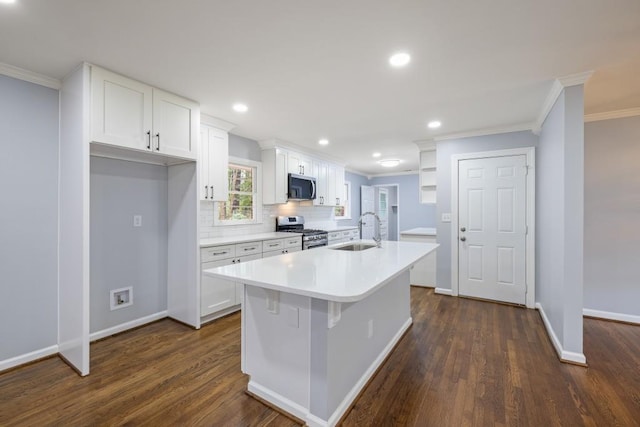 kitchen featuring sink, white cabinets, dark hardwood / wood-style flooring, stainless steel appliances, and a center island with sink