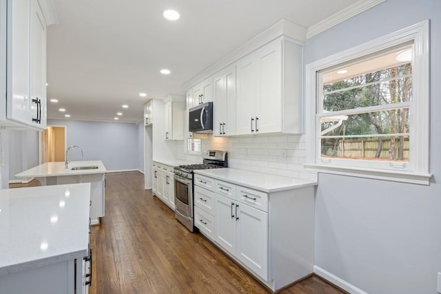 kitchen featuring backsplash, appliances with stainless steel finishes, and white cabinets