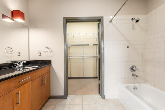 bathroom with tile patterned flooring, vanity, and tiled shower / bath