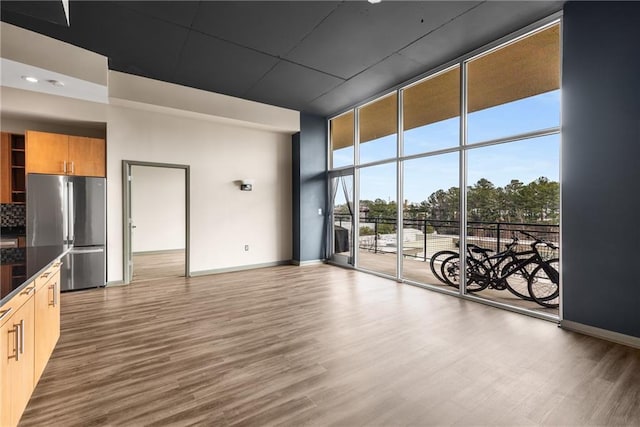 interior space with wood-type flooring and a wall of windows