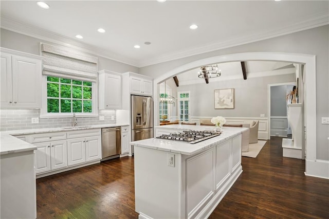 4555 Peachtree Dunwoody Rd, Sandy Springs, GA 30342 - kitchen with white cabinets, appliances with stainless steel finishes, a sink, arched walkways, and a kitchen island