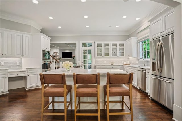 4555 Peachtree Dunwoody Rd, Sandy Springs, GA 30342 - kitchen with a center island, white cabinets, backsplash, and stainless steel appliances