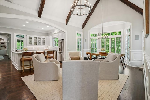 4555 Peachtree Dunwoody Rd, Sandy Springs, GA 30342 - living area featuring an inviting chandelier, lofted ceiling with beams, a decorative wall, arched walkways, and a wealth of natural light