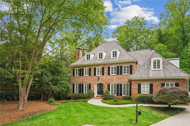 4555 Peachtree Dunwoody Rd, Sandy Springs, GA 30342 - georgian-style home with brick siding, a front lawn, and a chimney