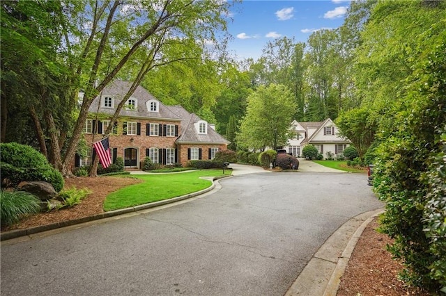 4555 Peachtree Dunwoody Rd, Sandy Springs, GA 30342 - colonial inspired home with a front yard, aphalt driveway, and brick siding
