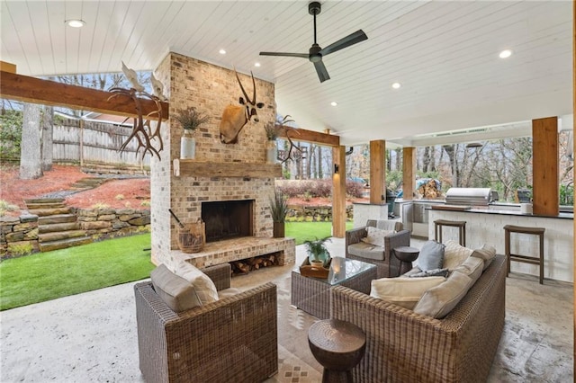 view of patio / terrace featuring area for grilling, a ceiling fan, and an outdoor living space with a fireplace