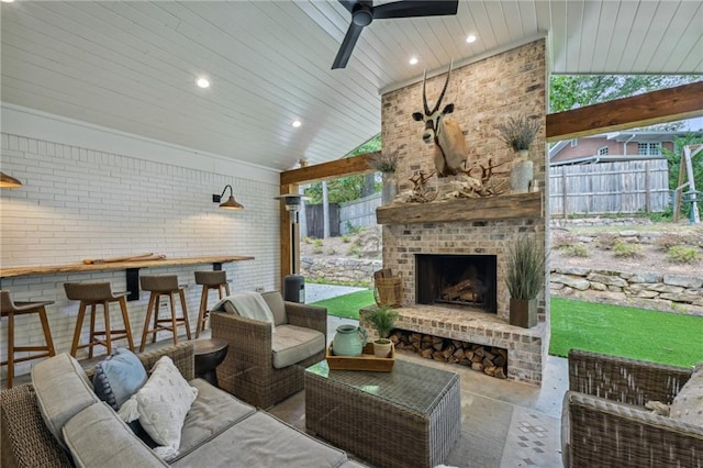 view of patio with a ceiling fan, an outdoor living space with a fireplace, and fence