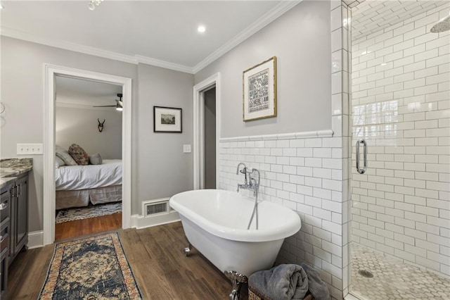 ensuite bathroom with a freestanding tub, visible vents, tile walls, a shower stall, and crown molding