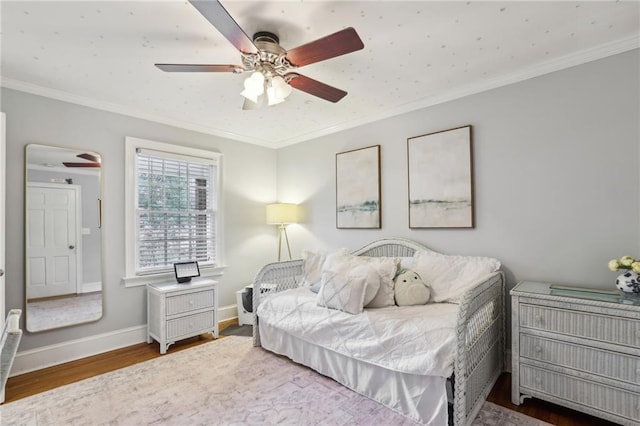 bedroom featuring ornamental molding, a ceiling fan, baseboards, and wood finished floors