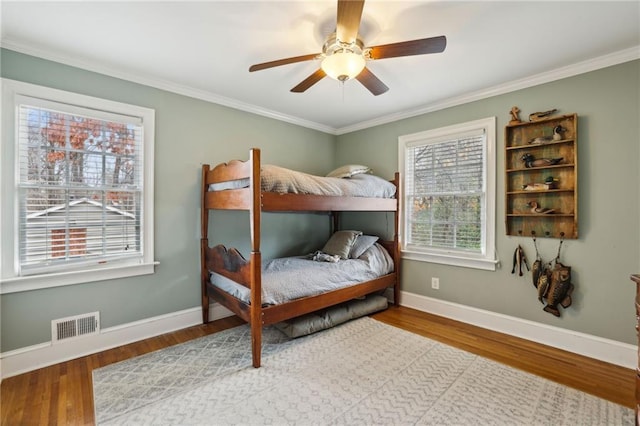 bedroom featuring visible vents, baseboards, and wood finished floors