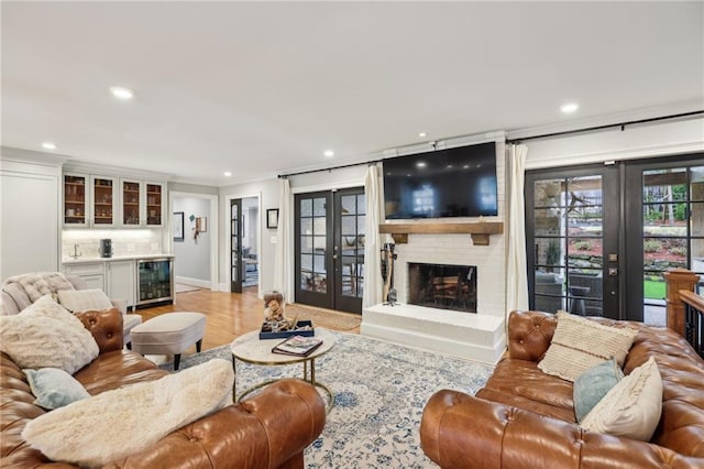 living area with bar, wine cooler, french doors, and a fireplace