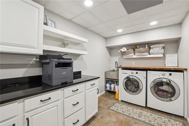 washroom with washer and dryer, a sink, recessed lighting, cabinet space, and baseboards