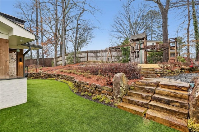 view of yard featuring a playground and fence