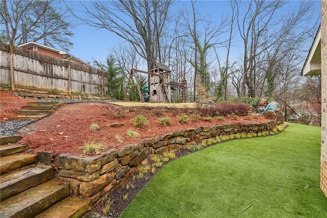 view of yard featuring a playground and fence