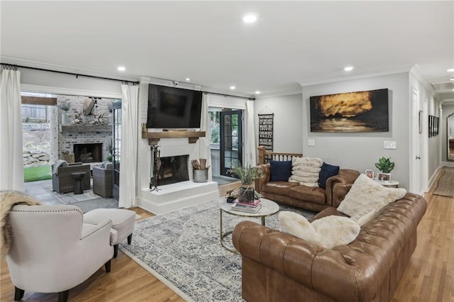 living room featuring wood finished floors, recessed lighting, a fireplace, and ornamental molding