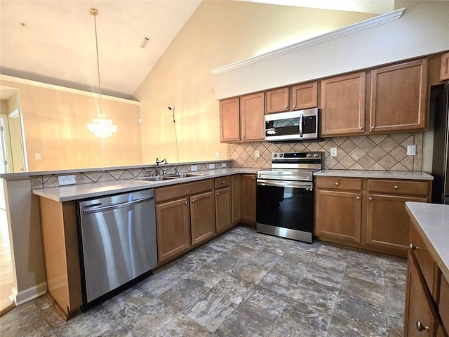 kitchen with brown cabinets, a sink, decorative backsplash, a peninsula, and appliances with stainless steel finishes