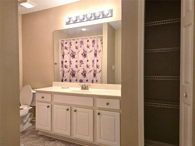 full bath featuring a spacious closet, toilet, vanity, and a shower with curtain