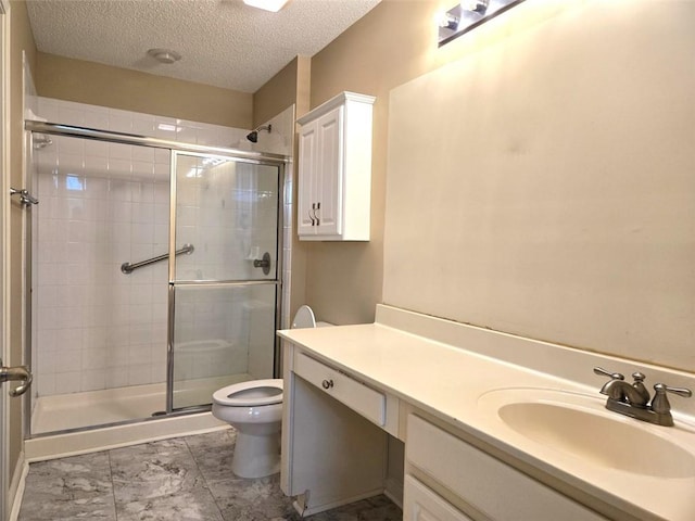 full bathroom featuring toilet, vanity, a textured ceiling, and a stall shower