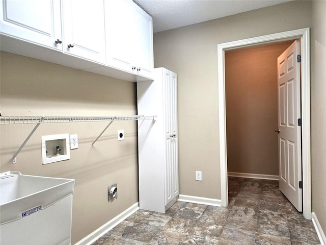 washroom with cabinet space, baseboards, a sink, and hookup for an electric dryer