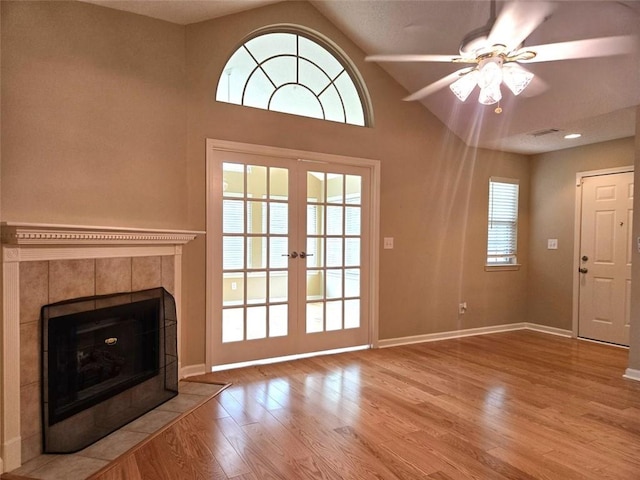 entryway featuring baseboards, wood finished floors, visible vents, and a tiled fireplace