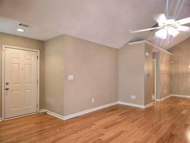 unfurnished room with light wood-style floors, lofted ceiling, and visible vents