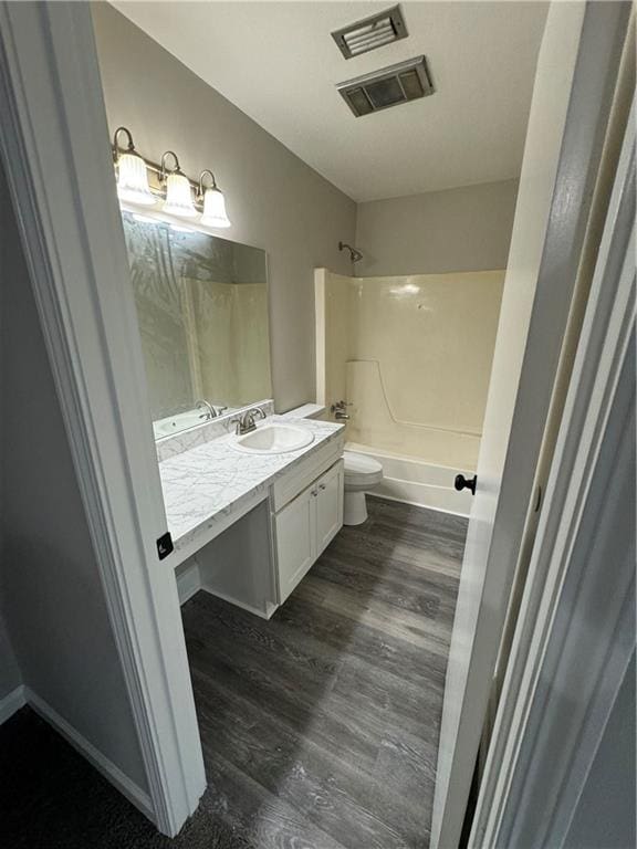 full bathroom with tub / shower combination, vanity, toilet, and hardwood / wood-style flooring