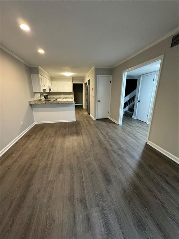 unfurnished living room with crown molding and dark hardwood / wood-style floors