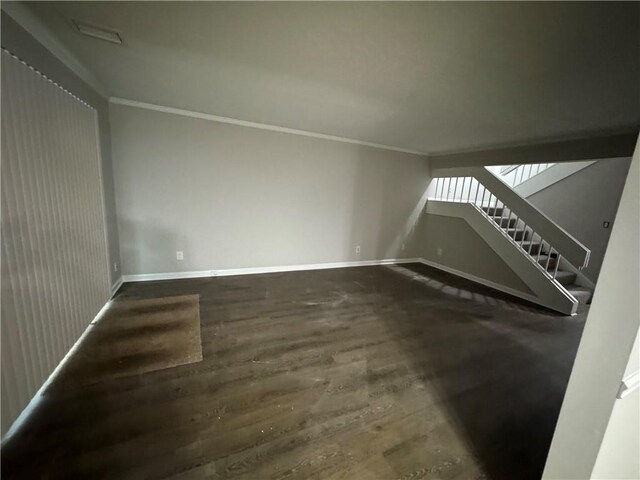 unfurnished living room featuring ornamental molding and dark hardwood / wood-style flooring