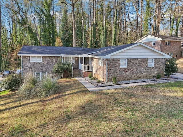 ranch-style home featuring a front lawn, covered porch, and brick siding