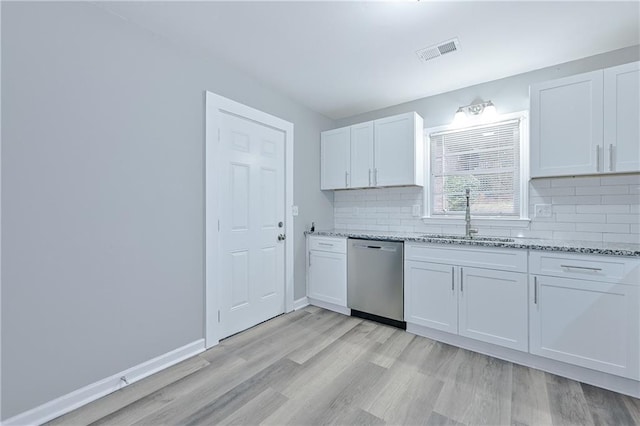 kitchen with visible vents, a sink, decorative backsplash, dishwasher, and light wood-type flooring