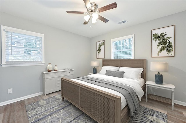 bedroom with visible vents, baseboards, light wood-style floors, and a ceiling fan