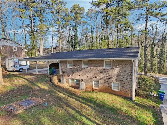 view of side of home with a carport, a yard, and brick siding