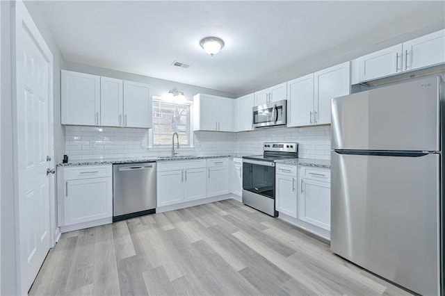 kitchen featuring a sink, visible vents, appliances with stainless steel finishes, and white cabinets