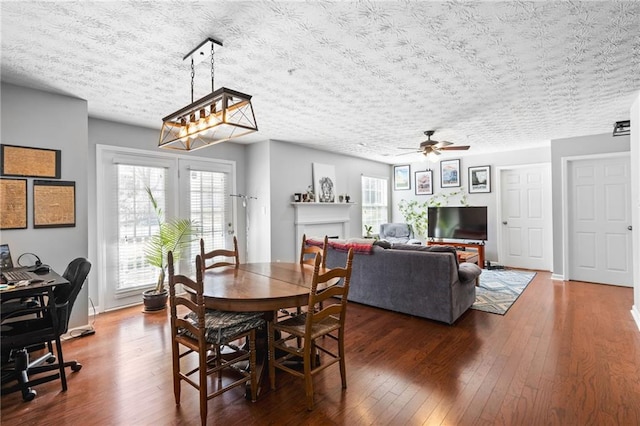 dining space featuring a wealth of natural light, wood-type flooring, a textured ceiling, and a ceiling fan
