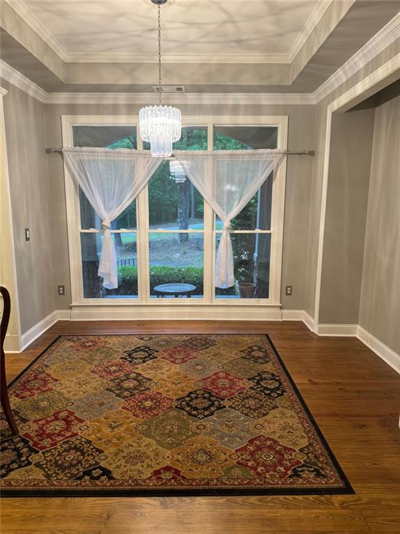 interior space featuring ornamental molding, an inviting chandelier, and hardwood / wood-style floors