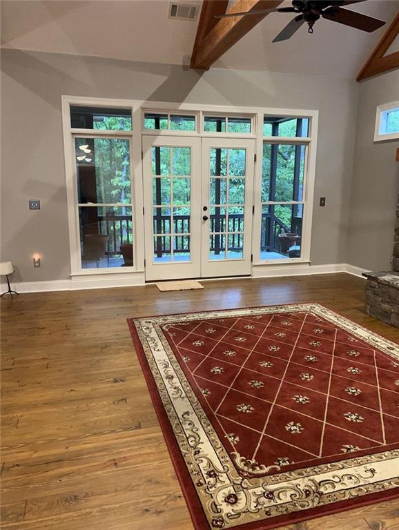 doorway with french doors, ceiling fan, lofted ceiling with beams, and hardwood / wood-style floors