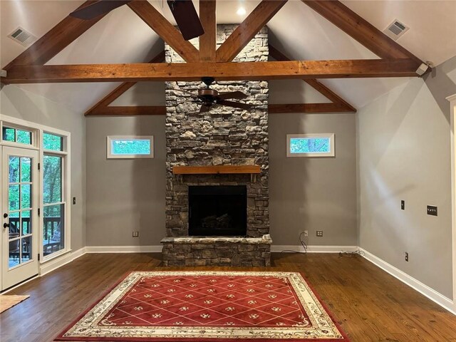 unfurnished living room featuring high vaulted ceiling, beamed ceiling, dark hardwood / wood-style flooring, and a stone fireplace