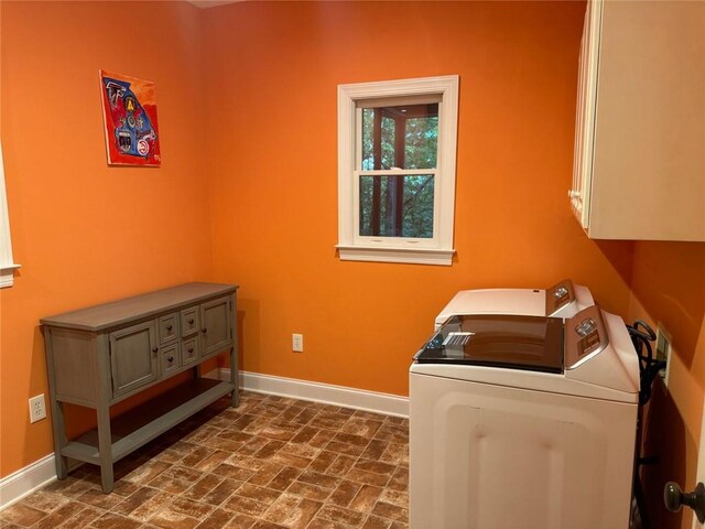 washroom featuring cabinets and washing machine and clothes dryer