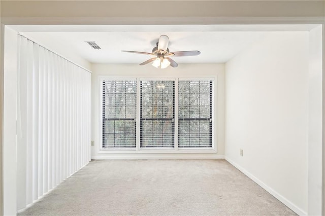 carpeted spare room with a wealth of natural light and ceiling fan