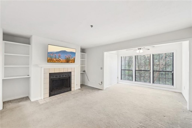 unfurnished living room with ceiling fan, light carpet, and a fireplace