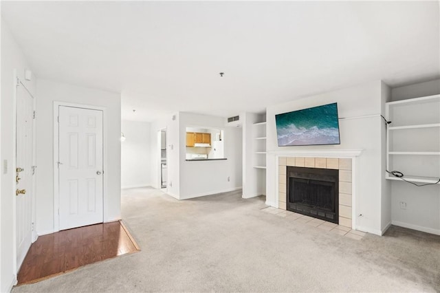 unfurnished living room featuring light colored carpet and a fireplace