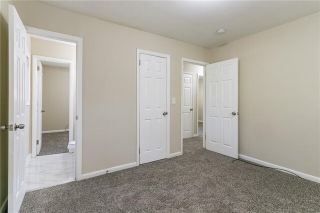 unfurnished bedroom with dark carpet