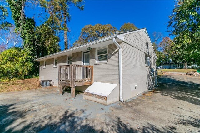 exterior space with a wooden deck and central AC unit
