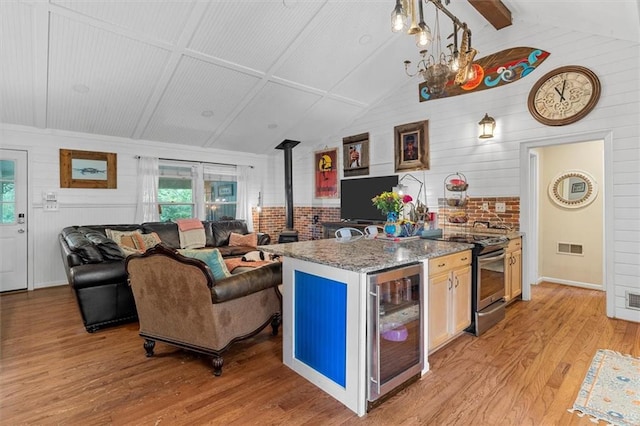 8669 Davis St, Braselton, GA 30517 - kitchen with wine cooler, a wood stove, electric stove, light wood-style flooring, and light stone countertops