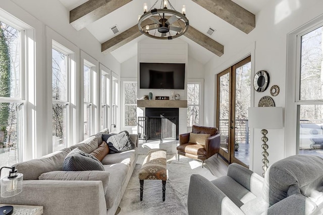 sunroom / solarium with ceiling fan with notable chandelier and lofted ceiling with beams