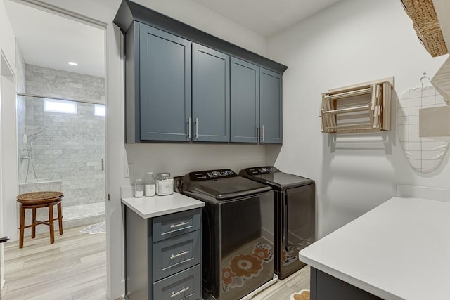 washroom featuring light hardwood / wood-style floors, cabinets, and washer and dryer