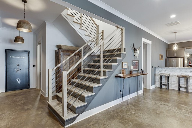 staircase with crown molding and concrete flooring